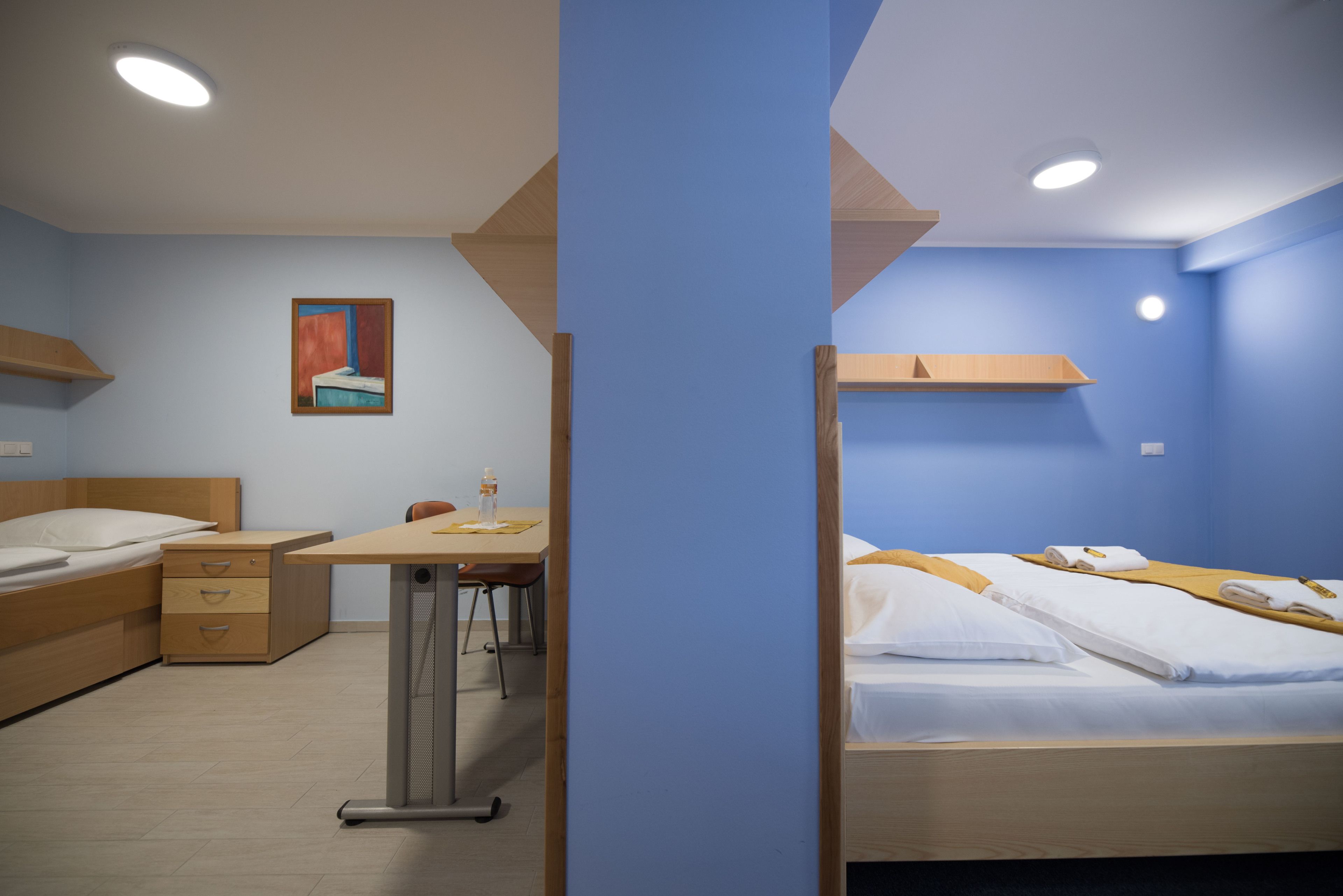 Une chambre d’hôtel avec deux lits, un bureau et une chaise.