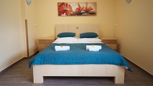 Una cama bien hecha con un edredón azul, dos almohadas y dos toallas.
