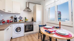 Eine moderne Küche mit Einbauwaschmaschine, Backofen und Essbereich, gedeckt für zwei Personen.