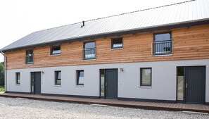 Un bâtiment à deux étages doté d’une façade en bois et d’une couleur extérieure grise.