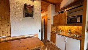 Une cuisine chaleureuse avec des meubles en bois, un four à micro-ondes et un dosseret carrelé.