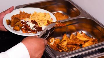 A buffet with various food items including potatoes, scrambled eggs, and toast.