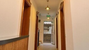 A hallway with a wooden reception desk, a staircase, and a ceiling light fixture. - Brothers Cesme Hotel (Cesme)
