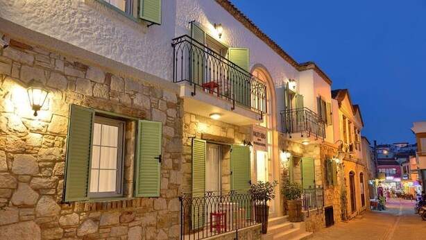 A stone building with green shutters, a balcony, and a sign that reads "MOTEL". - Brothers Cesme Hotel (Cesme)