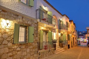 A stone building with green shutters, a balcony, and a sign that reads "MOTEL". - Brothers Cesme Hotel (Cesme)