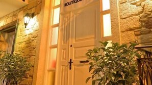A stone building with a white door labeled "Brothers Boutique Hotel." - Brothers Cesme Hotel (Cesme)
