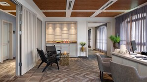 A modern hotel lobby with a herringbone-patterned floor, a central island with seating, and a reception desk with a computer monitor. - Edmond Luxury Hotel & Spa (Rosh Pinna)