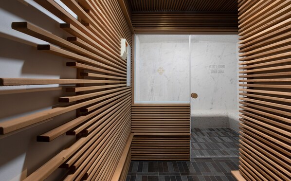 A modern steam sauna with wooden slats on the walls and a tiled floor.