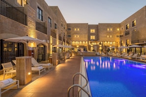 Alberca al aire libre y camastros 