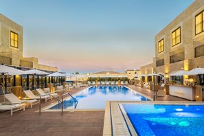 Una piscina al aire libre, sillones reclinables de piscina
