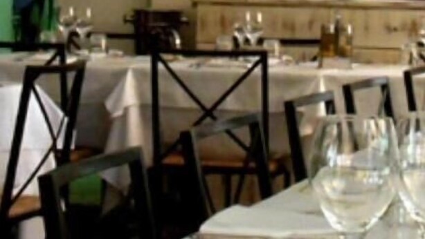 A dining area with tables set for a meal, a painting of sunflowers on the wall, and a fire extinguisher mounted on the wall. - Hotel Illi  (Massa)