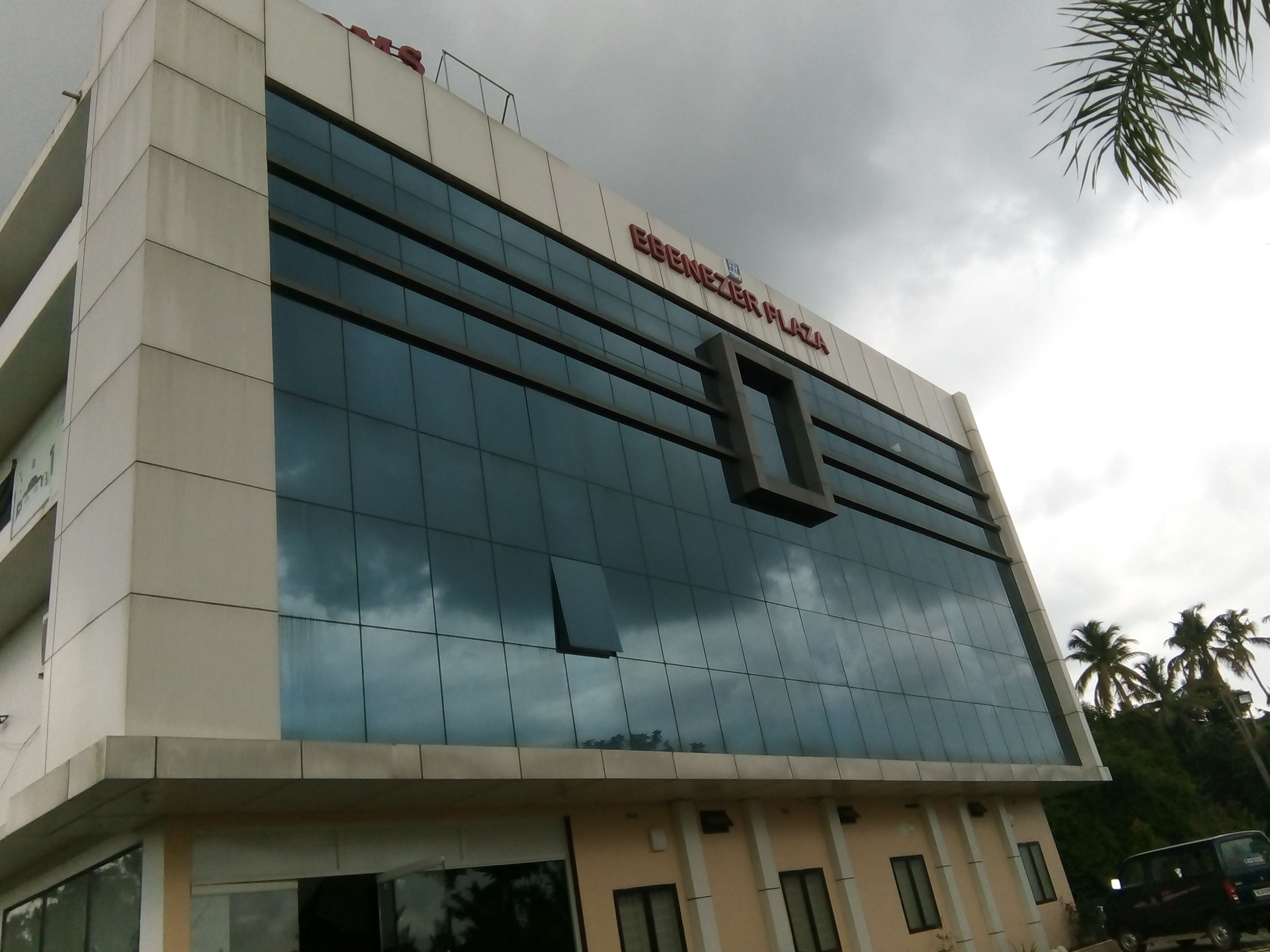 A modern building with a glass facade and a sign reading "RENEKER PLAZA".