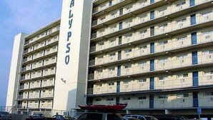 A multi-story building with balconies and a vertical sign reading "CALYPSO". - Calypso unit 701 located at 62nd street and Ocean front (Ocean City)