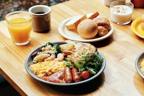 A meal with various dishes including pasta, vegetables, and meats on a wooden table. - WPÜ HOTEL HAKONE (Hakone)