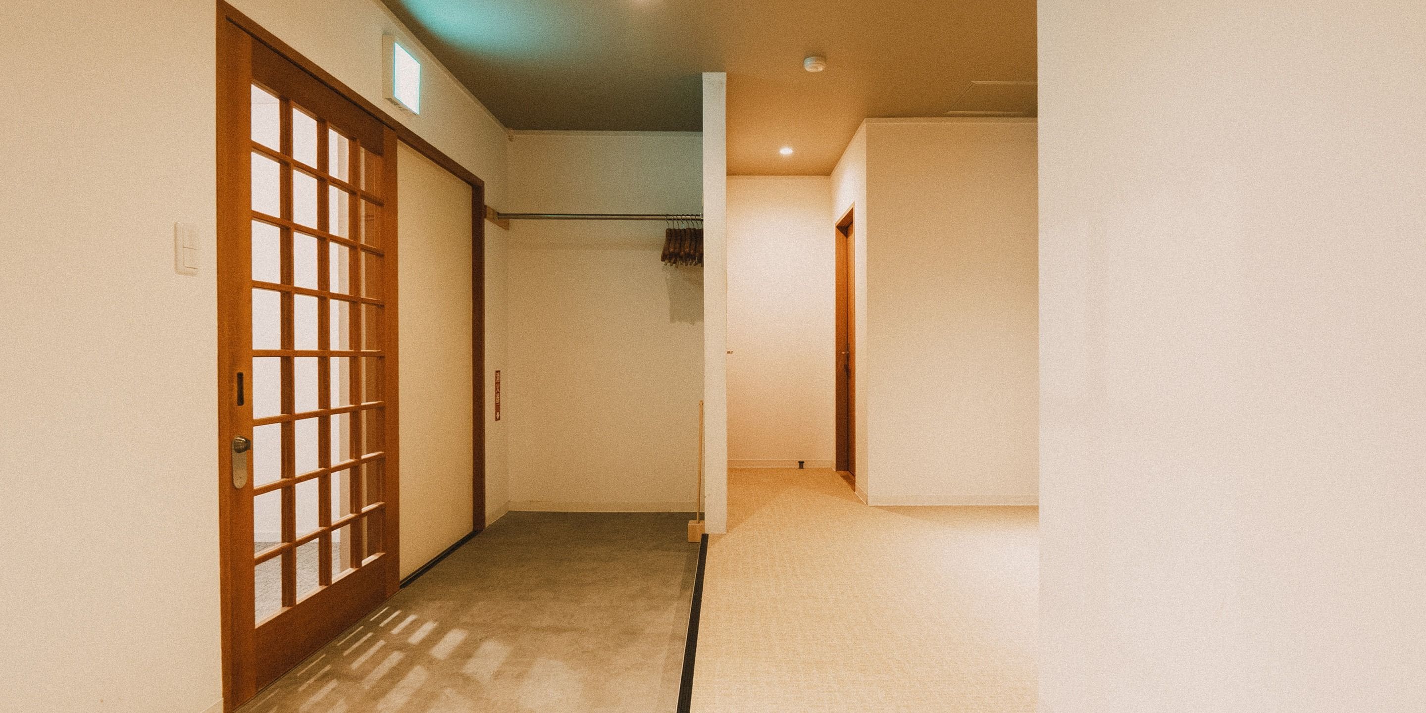 A hallway with a wooden door and a white wall.