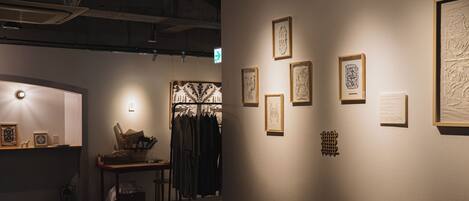 An art gallery with framed artworks on the walls, a reception desk, and a seating area.