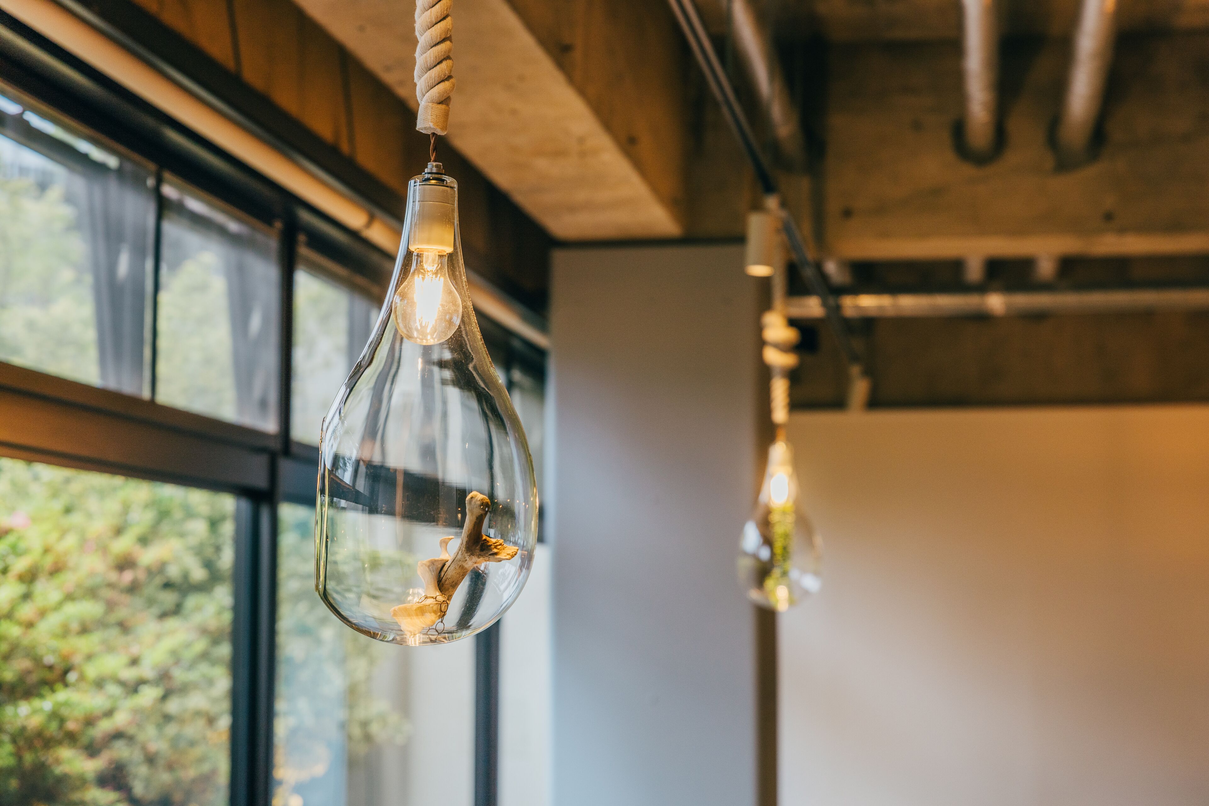 A modern interior with a hanging light fixture featuring a bird inside.