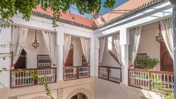 A courtyard with multiple balconies, arched doorways, and hanging lanterns.
