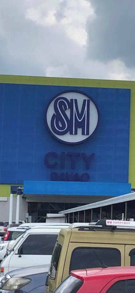 Un bâtiment dont la façade est ornée d’un grand logo « SM » et de l’inscription « CITY SALES ».