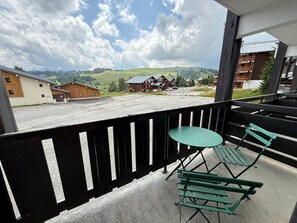 A balcony with a view of a rural landscape, including houses and a road.