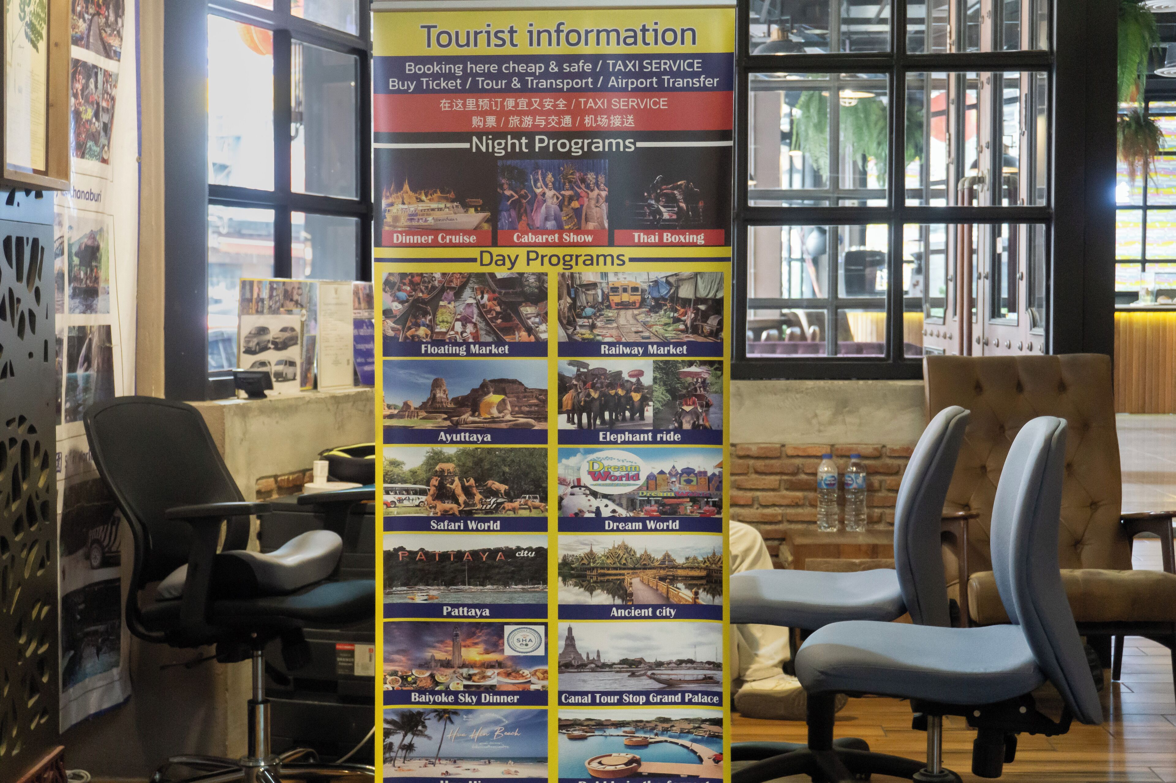 A tourist information board with sections for night and day programs, including activities like a dinner cruise, elephant ride, and a floating market.