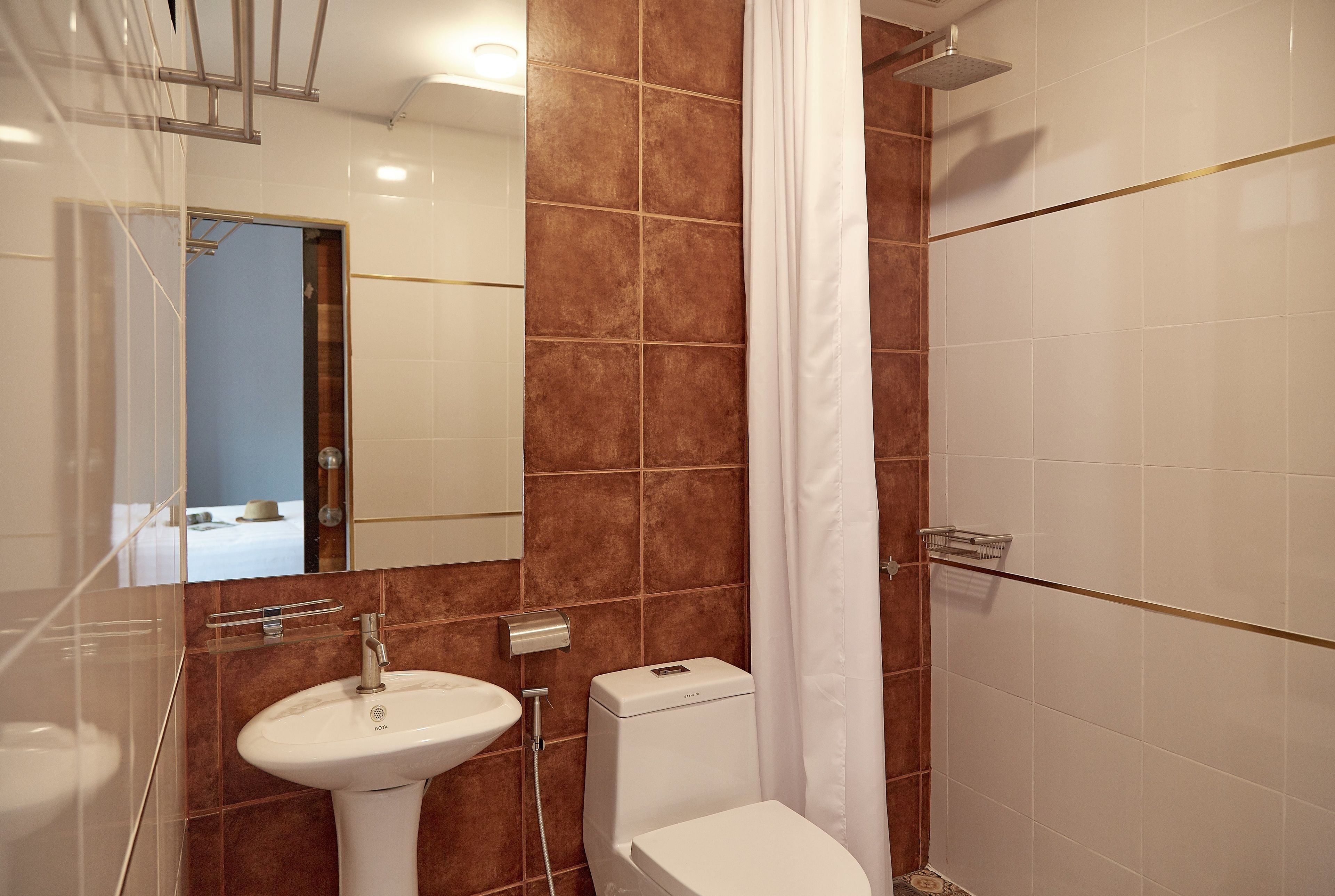 Un baño con un lavamanos blanco, un inodoro y una zona de ducha.