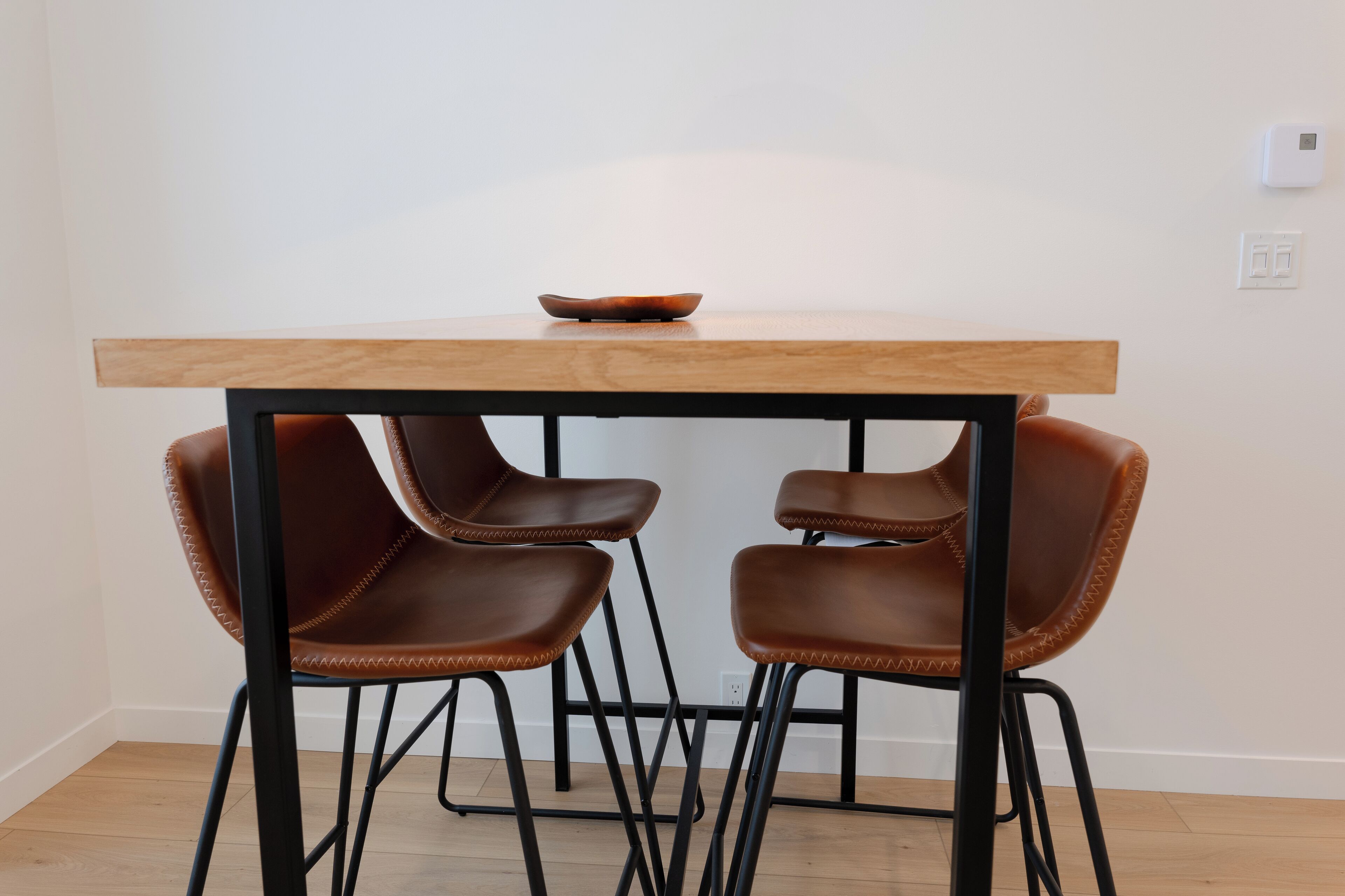 Une table à manger avec deux chaises et un bol posé dessus.