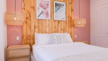A bedroom with a wooden headboard, two wall-mounted lamps, a bed with white bedding, and two nightstands with wicker drawers.