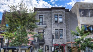 A multi-story building with a ground-floor restaurant, a visible staircase, and a small outdoor seating area.