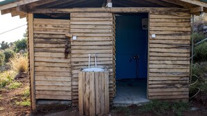 A rustic wooden cabin with a sloped roof and a small door leading inside.