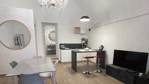 Una cocina moderna con comedor, televisor y candelabro.