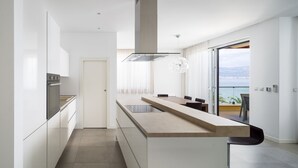 Una cocina moderna con una isla central, horno empotrado y un amplio ventanal con vistas panorámicas.