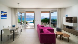 A modern living room with a pink sofa, dining area, and a TV stand. - Beachfront Villa Lemonade with Pool III (Trogir)