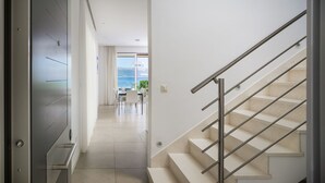 A modern interior with a staircase, a dining area, and a view of the sea. - Beachfront Villa Lemonade with Pool III (Trogir)