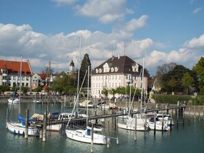 Eine Marina mit mehreren anglegerten Booten, ein großes Gebäude mit rotem Dach und ein klarer Himmel.