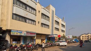 A multi-story building with various shops on the ground floor, including a hotel and a motorcycle rental service. - Hotel Arma (Mumbai)