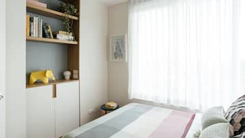 Cozy retreat with a bed, bedside table, and wardrobe, perfect for a restful stay.