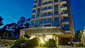 A multi-story hotel with a modern design, featuring balconies on each floor and a covered entrance area. - Padgett Place - Deluxe Suites (Cebu City)