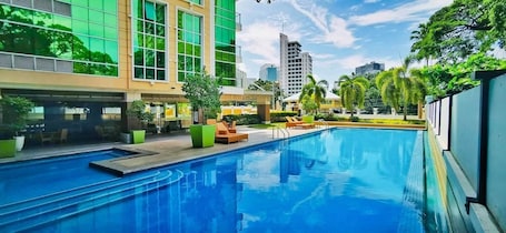 Una piscina al aire libre, sillones reclinables de piscina