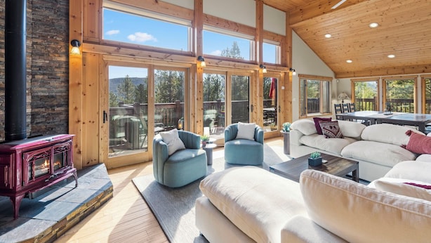 A spacious living room with a high ceiling, large windows, and a fireplace. - Spectacular Peak 7 Open and Great Views! STR21-01365 (Breckenridge)