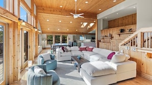 A spacious living area with a large sectional sofa, a coffee table, and a ceiling fan. There is a kitchen area visible in the background. - Spectacular Peak 7 Open and Great Views! STR21-01365 (Breckenridge)