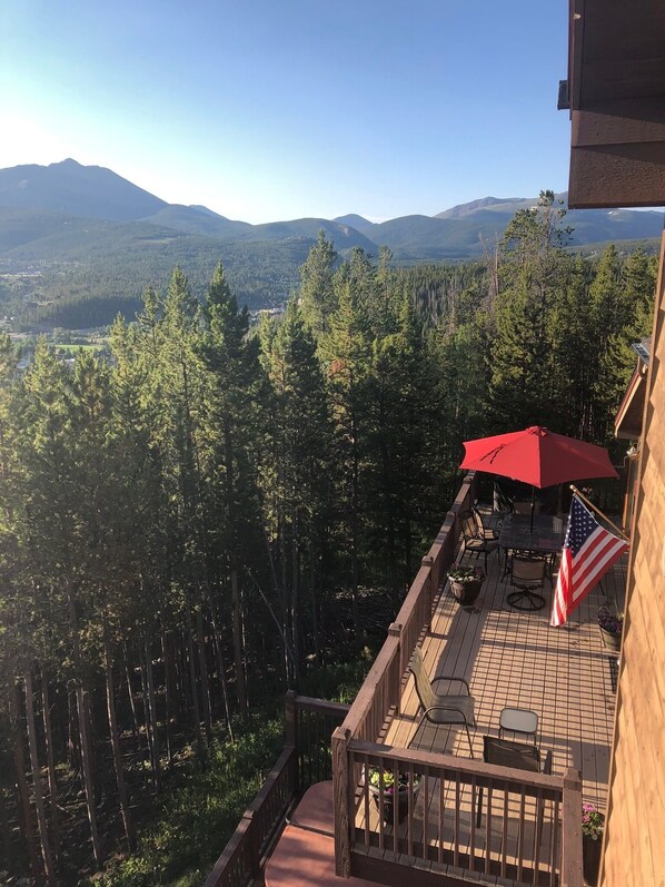 Eine Terrasse mit Gartenmöbeln, einer amerikanischen Flagge und einem roten Sonnenschirm.