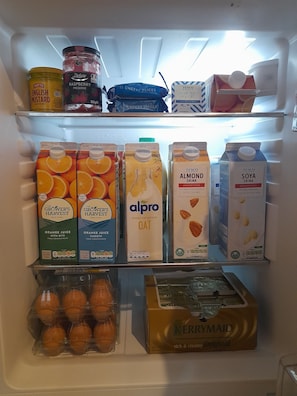 Un frigorífic ple d'àmples assortiments d'aliments, com ara suc d'aranja, beguda d'ametlles i iogurt.