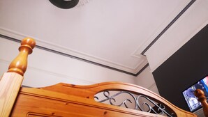 A wooden bed frame with a decorative headboard and a ceiling with a white and blue design. - EuroVilla (Belfast)