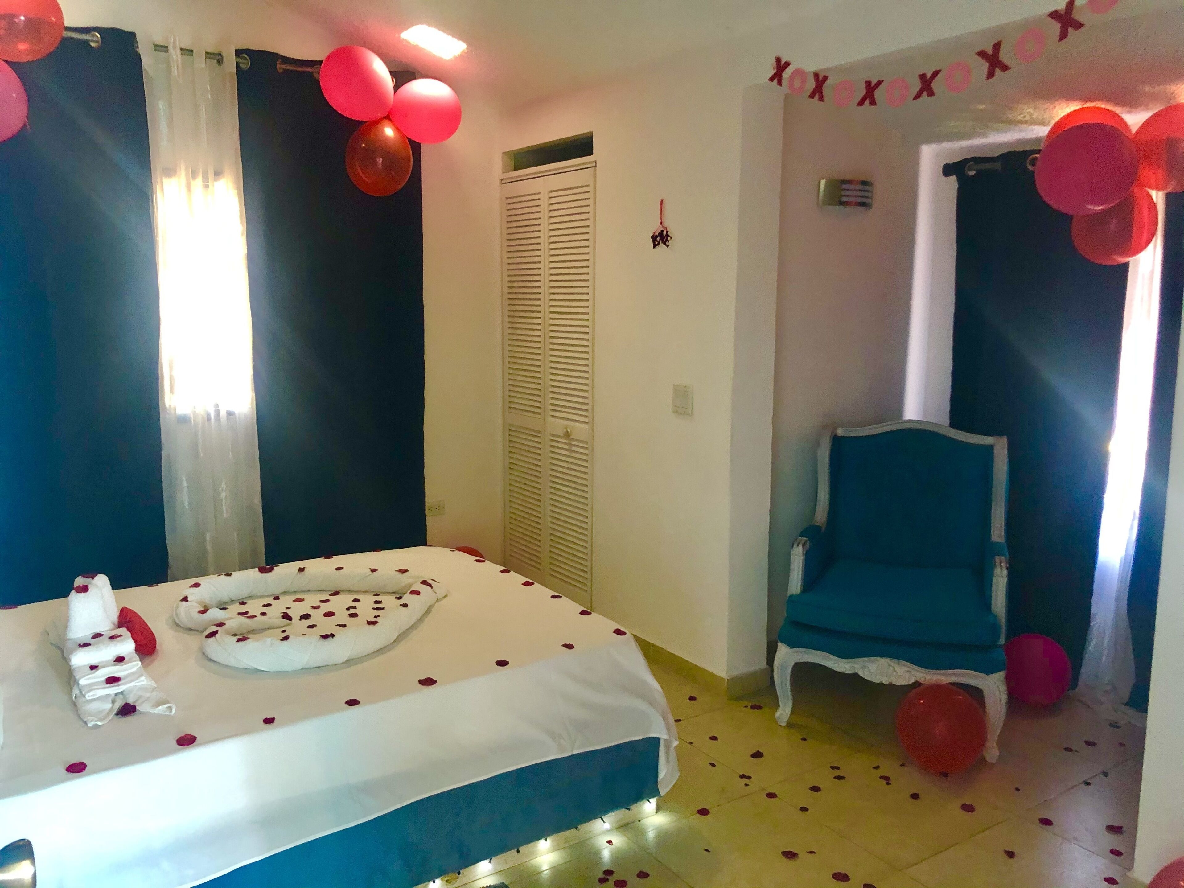 Une chambre à coucher avec un lit, une chaise et des ballons.