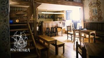 Un interior de madera de varios niveles, con una zona de bar y asientos.