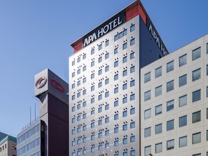 A hotel building with a modern design, featuring a prominent sign at the top.
