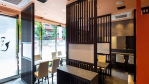 Un intérieur moderne comprenant un espace salon, séparé par des lambris verticaux, et une cuisine dotée d’une grande fenêtre.