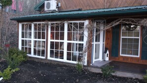 A wooden building with large windows and a green roof. - The Guest House (Schellsburg)