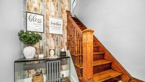 Una escalera de madera con una consola de vidrio y objetos decorativos.